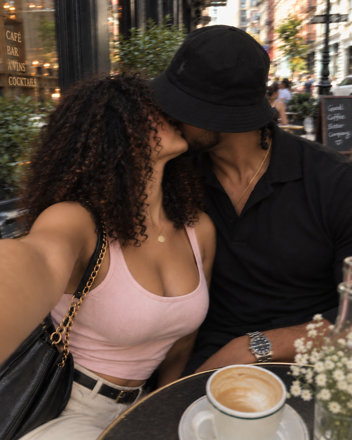 An anonymous couple sharing a kiss over a lavender latte at a city café